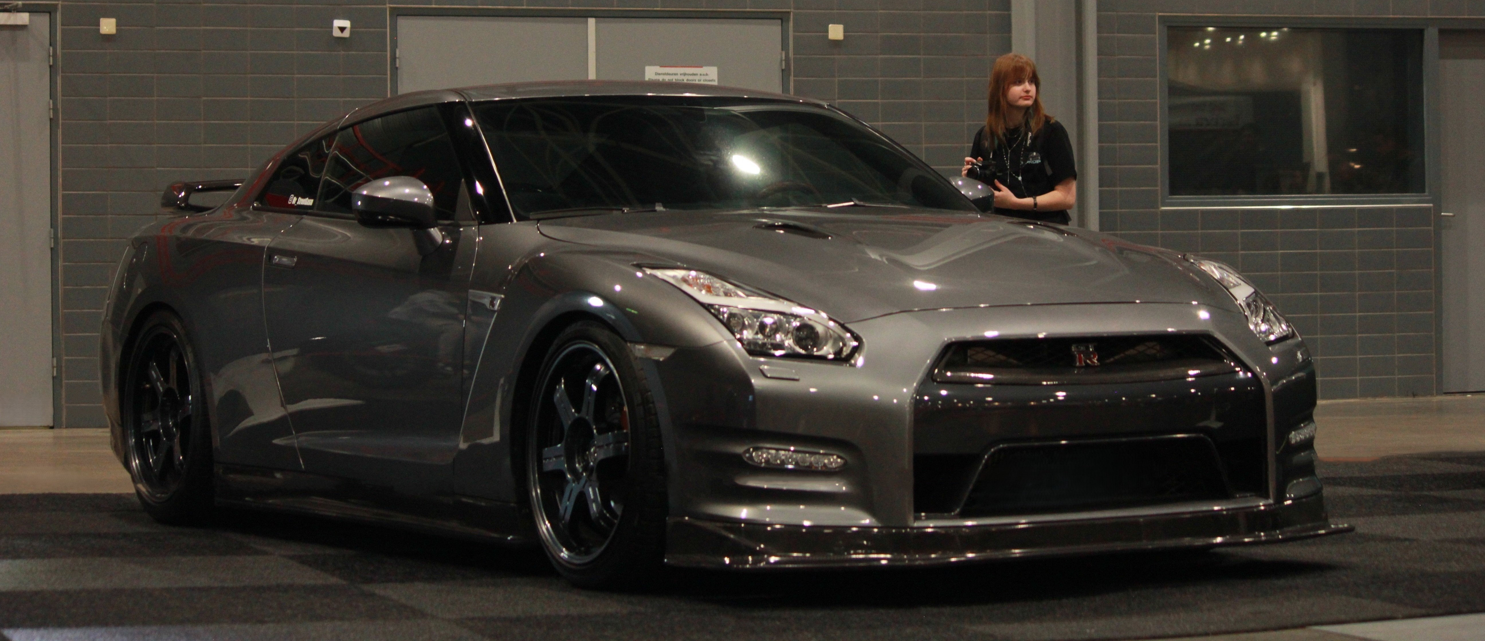 Clean Nissan GTR with a girl standing behind it